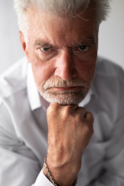 Homme senior élégant posant en chemise blanche