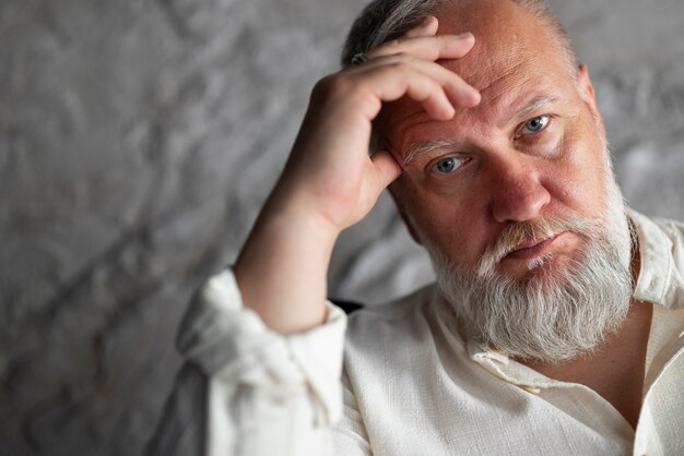 Homme senior élégant posant en chemise blanche