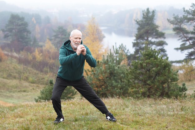 Homme senior expressif posant en plein air