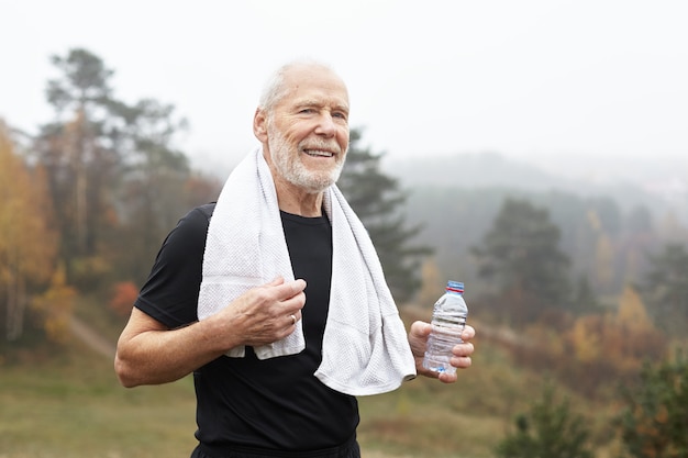 Homme senior expressif posant en plein air