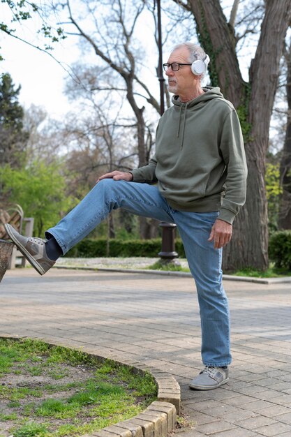 Homme senior moderne se détendre dans le parc