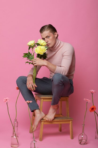 Homme sensible plein coup posant avec un fond rose