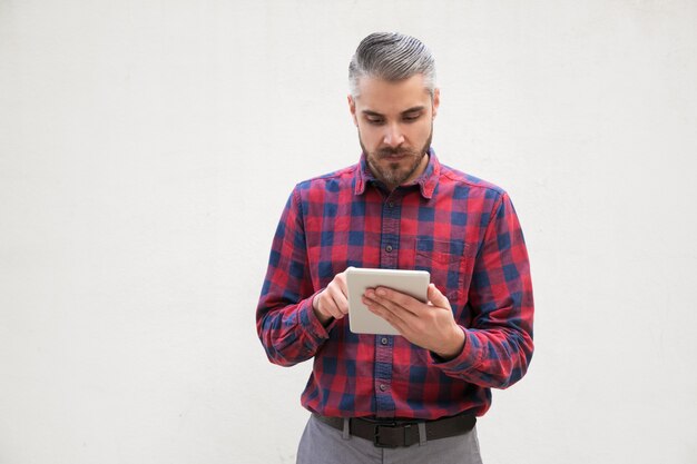 Homme sérieux à l'aide de tablet pc