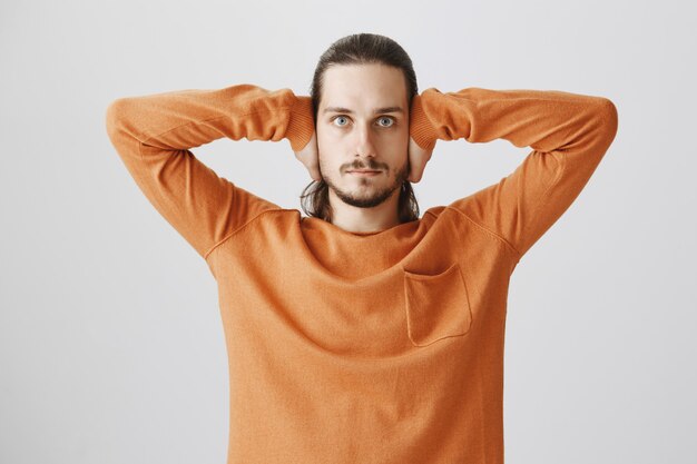 Un homme sérieux ferme les oreilles, ne veut pas écouter