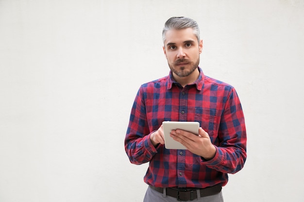 Homme sérieux avec tablette numérique à la recherche