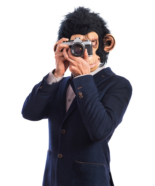 Homme singe photographiant sur fond blanc