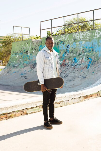 Homme avec skateboard en milieu urbain