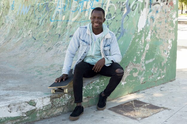 Homme avec skateboard en milieu urbain