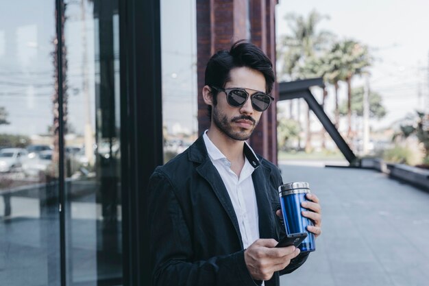 Homme avec smartphone et tasse