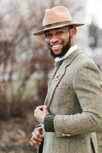 Photo gratuite homme smiley avec chapeau posant à l'extérieur