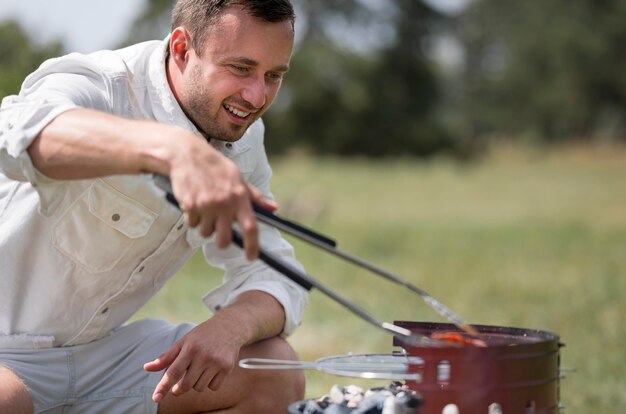 Homme Smiley participant au barbecue en plein air