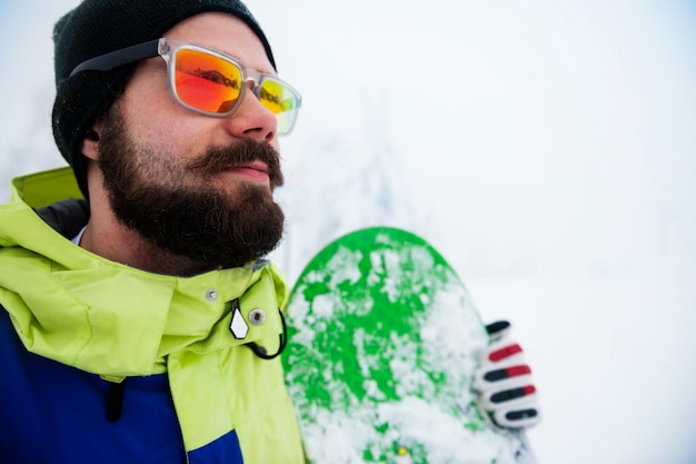 Homme avec snowboard pendant l'hiver