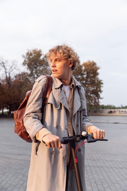 Homme avec son scooter électrique dans la ville