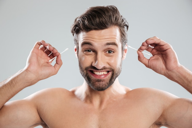 Homme souriant à l'aide de bâtons d'oreille