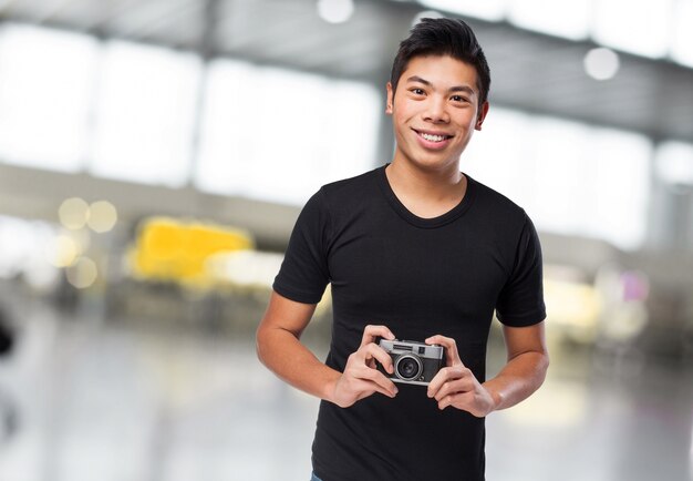 Homme souriant avec un appareil photo