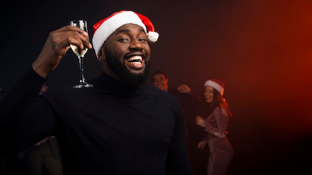 Homme souriant applaudissant avec un verre de champagne pour le nouvel an