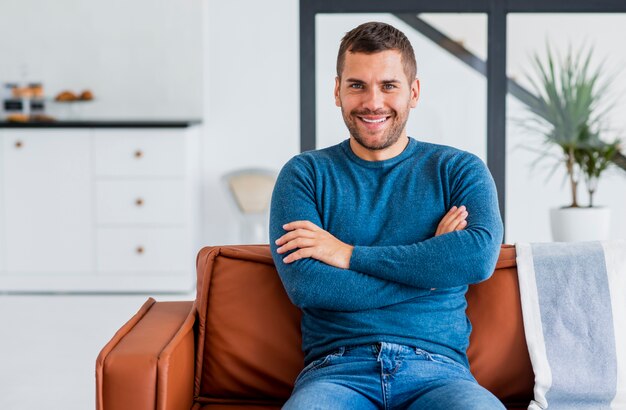 Homme souriant avec les bras croisés en regardant la caméra