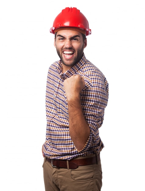 L&#39;homme souriant avec un casque rouge et un poing levé