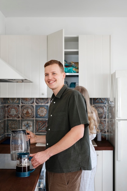 Photo gratuite homme souriant à coup moyen avec une cafetière