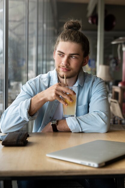 Homme souriant à coup moyen avec un chignon désordonné