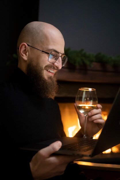 Homme souriant à coup moyen à une date virtuelle avec appareil