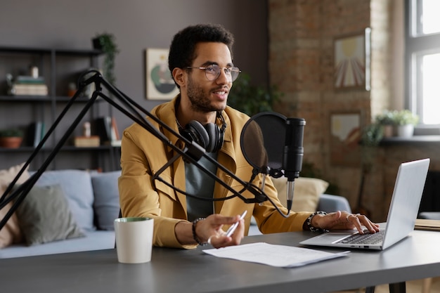 Homme souriant à coup moyen enregistrant un podcast