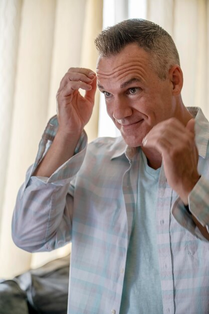 Homme souriant de coup moyen à l'intérieur