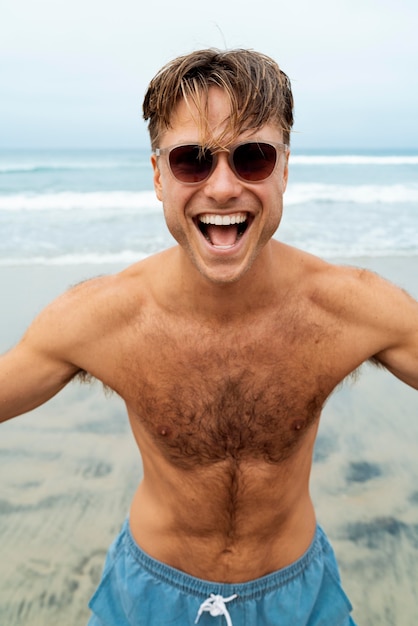 Photo gratuite homme souriant de coup moyen avec des lunettes de soleil