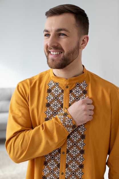 Photo gratuite homme souriant à coup moyen portant une chemise ukrainienne