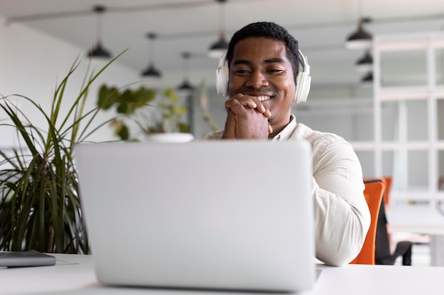 Homme souriant de coup moyen portant des écouteurs