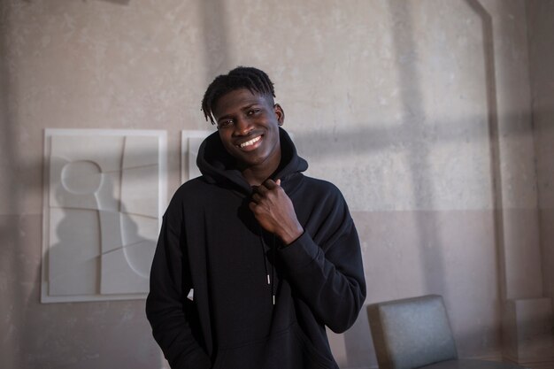 Homme souriant à coup moyen portant un sweat à capuche noir