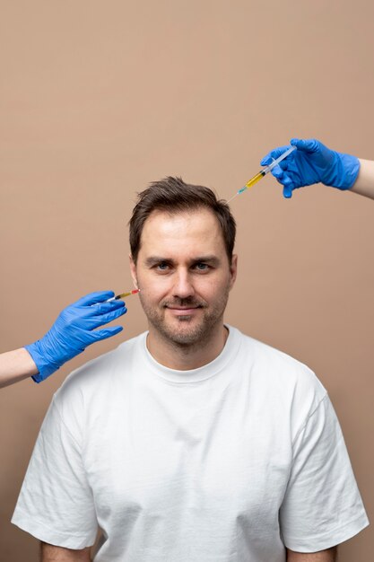 Homme souriant à coup moyen recevant une injection de prp