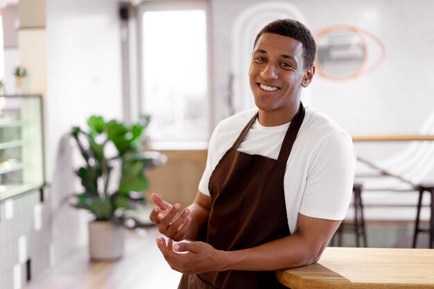 Homme souriant de coup moyen avec tablier