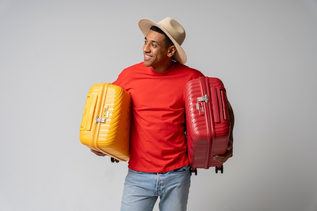 Photo gratuite homme souriant de coup moyen tenant des bagages