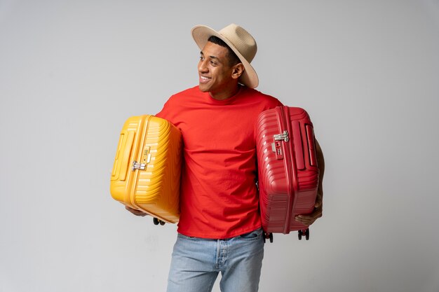 Homme souriant de coup moyen tenant des bagages