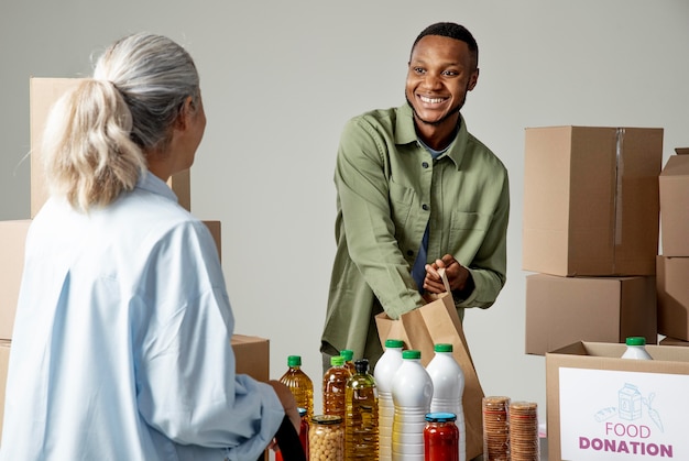 Homme souriant de coup moyen tenant un sac en papier