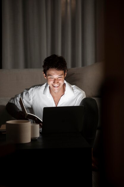 Homme souriant de coup moyen travaillant à domicile