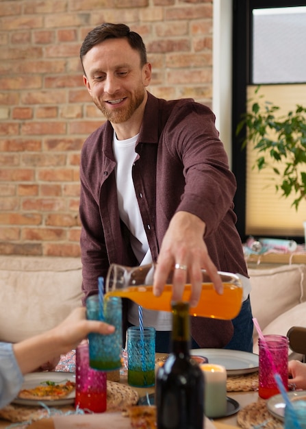 Photo gratuite homme souriant à coup moyen versant une boisson