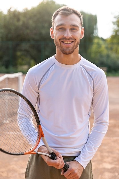 Photo gratuite homme souriant sur un court de tennis