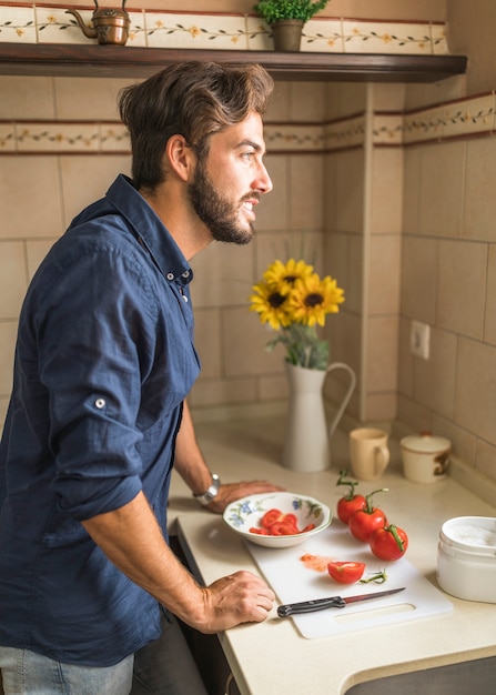 Photo gratuite homme souriant, debout au comptoir de la cuisine