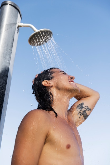 Homme souriant à faible angle prenant une douche