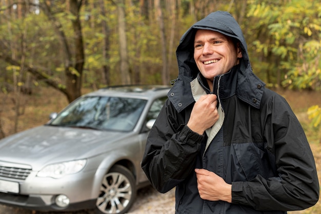 Homme souriant fermant sa veste d'hiver