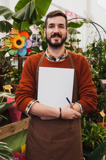 Homme souriant avec une feuille de papier