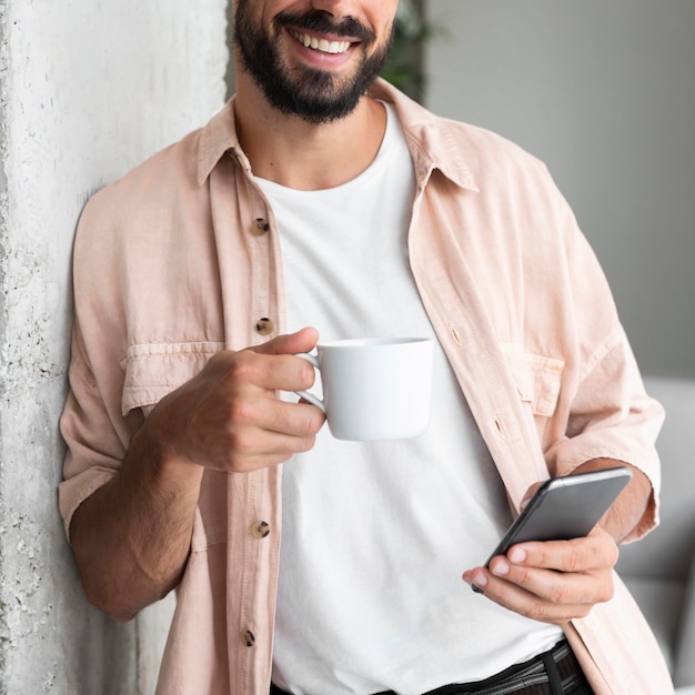 Homme souriant gros plan avec smartphone