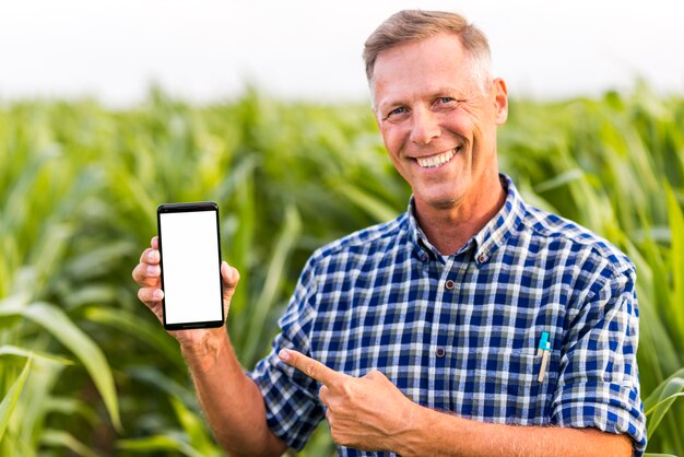 Homme souriant indiquant la maquette du téléphone