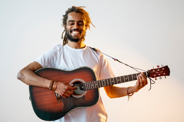 Homme souriant jouant de la guitare