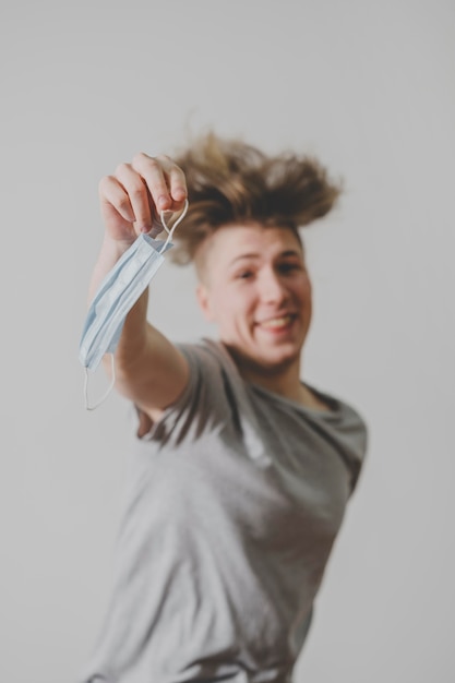 Photo gratuite homme souriant avec masque médical sautant en l'air