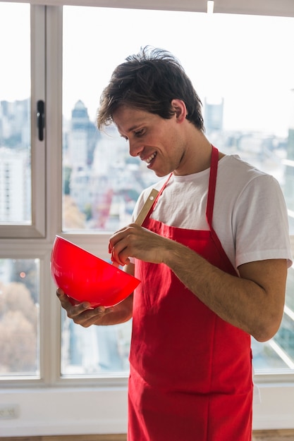 Homme souriant, mélange dans un bol