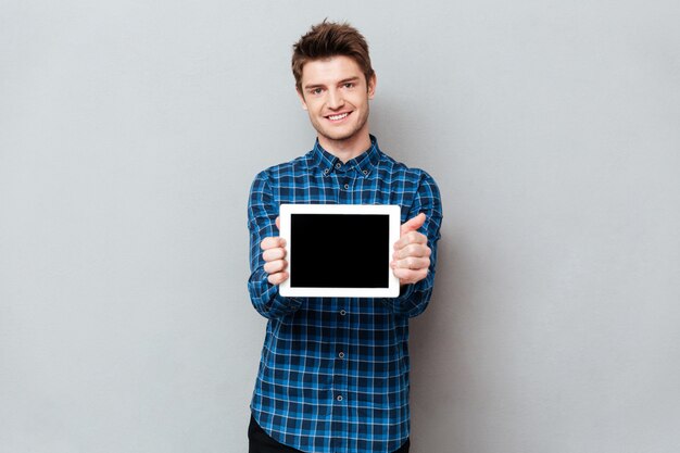 Homme souriant, montrant un écran blanc de la tablette tactile