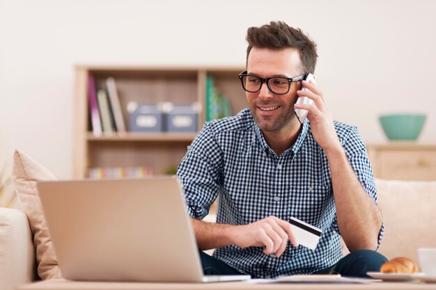 Homme souriant, passer commande par téléphone mobile